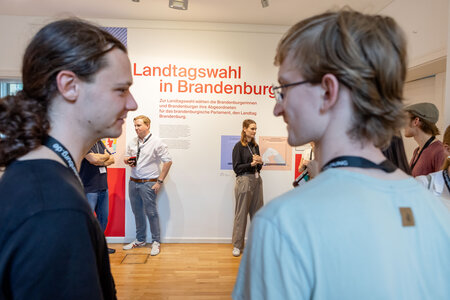 Besucher in der Ausstellung zur Landtagswahl in Brandenburg 2024